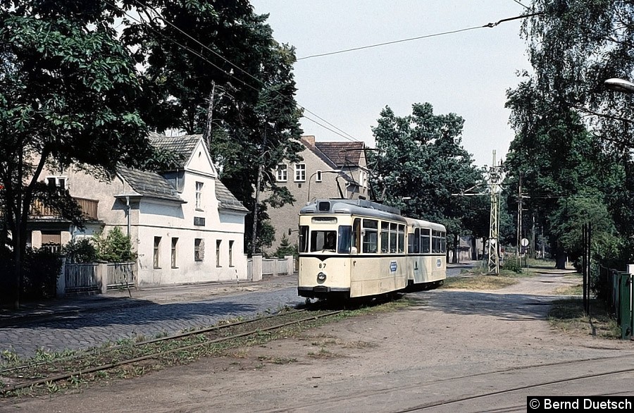 Noch einmal Tw 87, diesmal allerdings mit einem Gotha-Beiwagen im Schlepp auf der Fahrt nach Friedrichshagen. Der Zug passiert gerade die Einfahrt zum Betriebshof in Schöneiche.